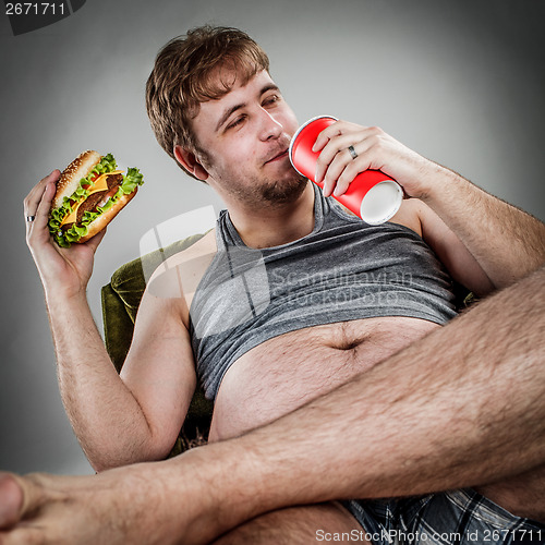 Image of Fat man eating hamburger