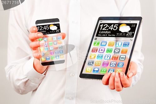 Image of Smartphone and tablet with transparent screen in human hands.