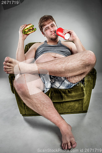 Image of Fat man eating hamburger