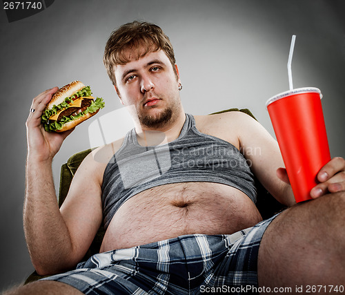 Image of Fat man eating hamburger