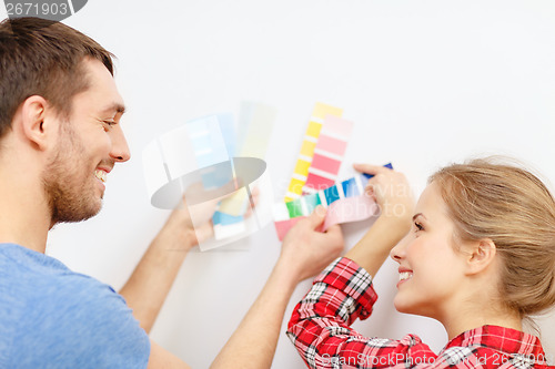 Image of smiling couple looking at color samples at home