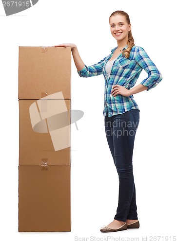 Image of young woman standing next to tower of boxes