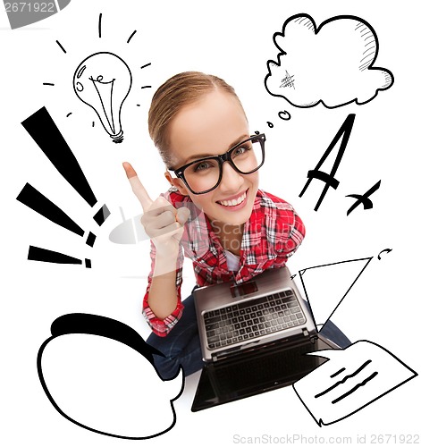 Image of smiling teenage girl in eyeglasses with laptop