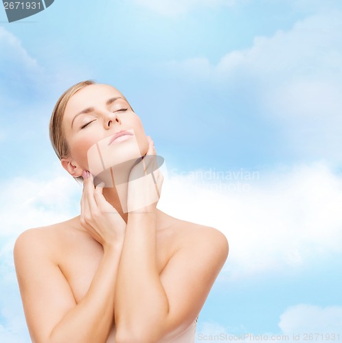 Image of beautiful woman touching her face with closed eyes