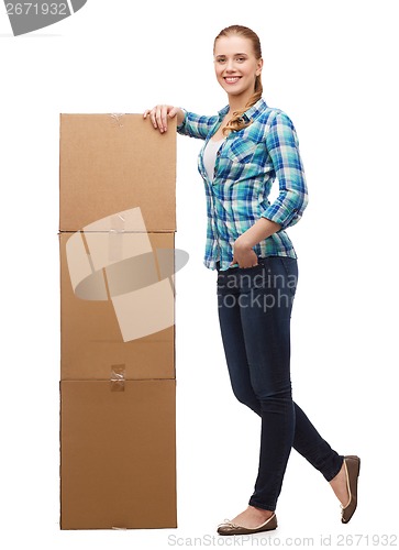 Image of young woman standing next to tower of boxes