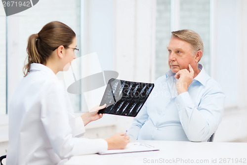 Image of female doctor with old man looking at x-ray