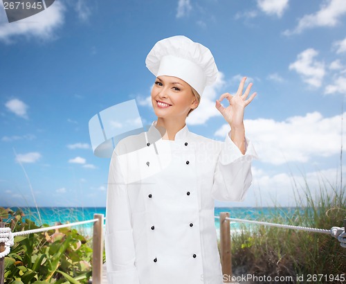 Image of smiling female chef showing ok hand sign