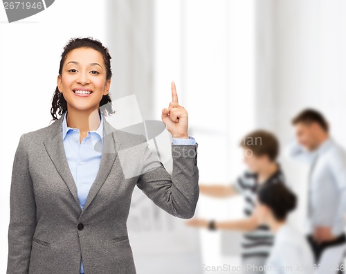 Image of smiling businesswoman with her finger up at office