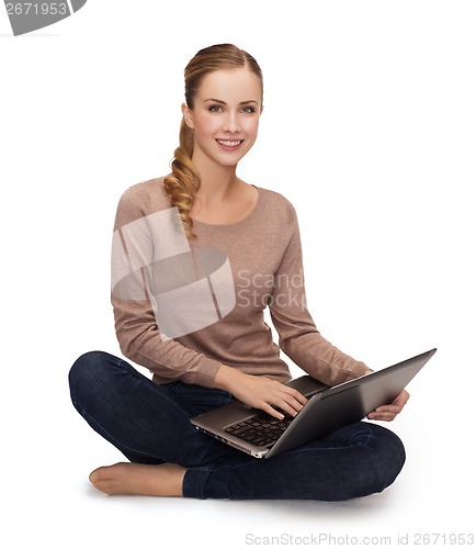 Image of young woman sitting on floor with laptop