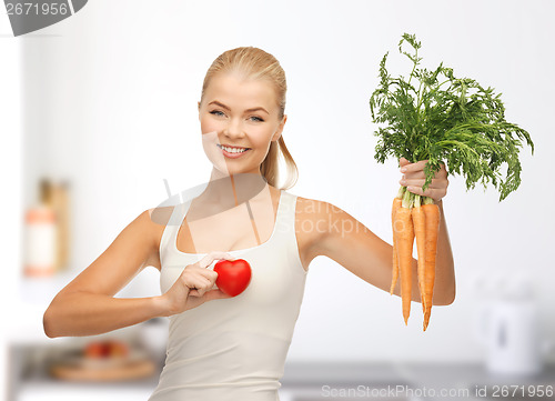 Image of woman holding heart symbol and carrots