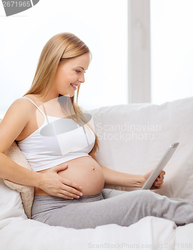 Image of smiling pregnant woman with tablet pc computer