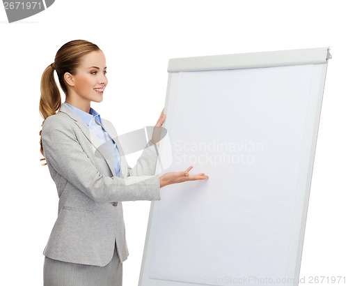 Image of smiling businesswoman standing next to flipboard
