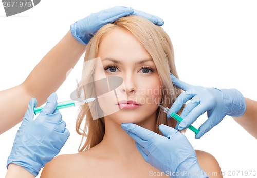 Image of woman face and beautician hands with syringes