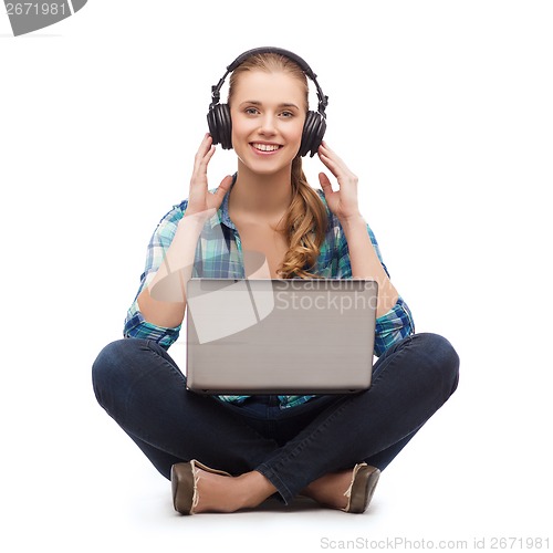 Image of young woman in casual clothes sitting on floor