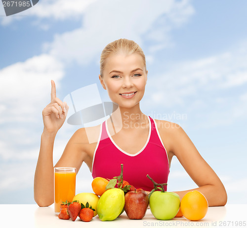 Image of woman with juice and fruits holding finger up