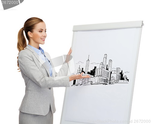 Image of smiling businesswoman standing next to flipboard