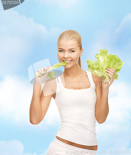 Image of smiling woman biting lettuce