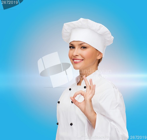 Image of smiling female chef showing ok hand sign