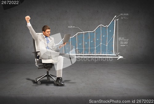 Image of young businessman sitting in chair with laptop