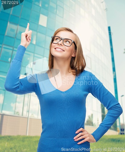 Image of smiling woman pointing her finger up