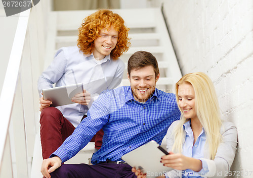 Image of team with tablet pc computer sitting on staircase