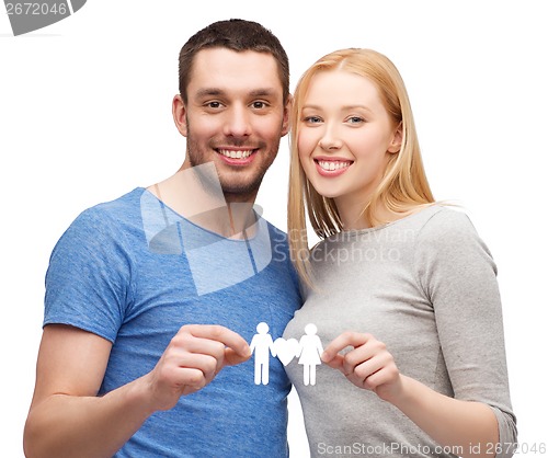 Image of smiling coule holding paper family with heart