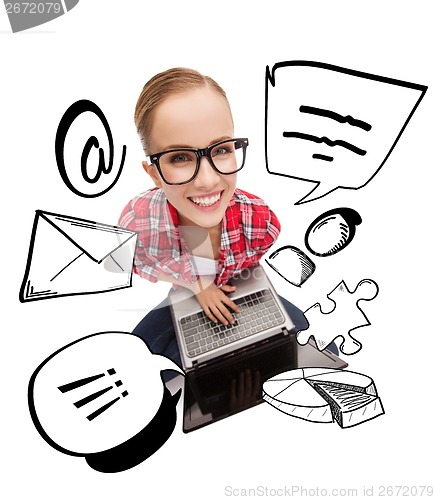 Image of smiling teenage girl in eyeglasses with laptop