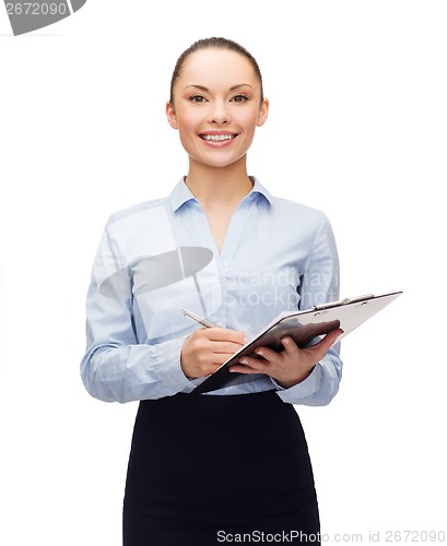 Image of young smiling businesswoman with clipboard and pen