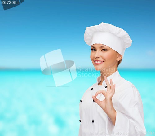 Image of smiling female chef showing ok hand sign