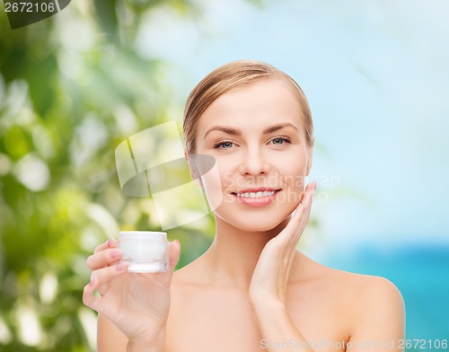 Image of woman applying cream on her skin