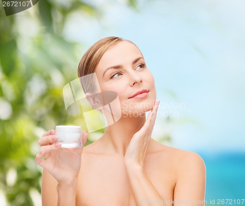 Image of woman applying cream on her skin