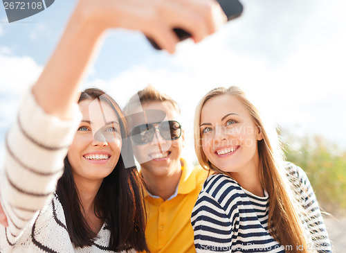 Image of friends taking picture with smartphone camera