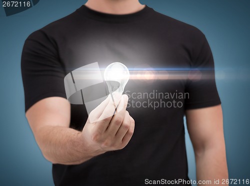 Image of close up of man holding light bulb