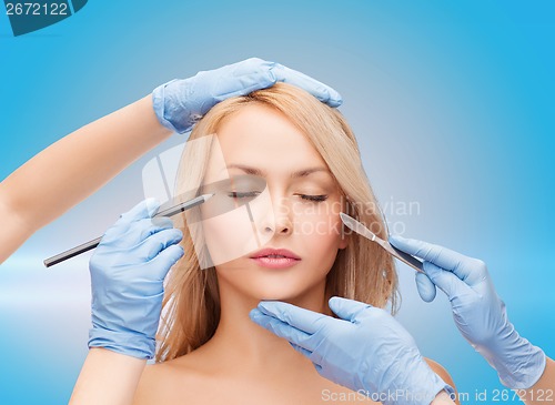 Image of woman and beautician hands with pencil and scalpel