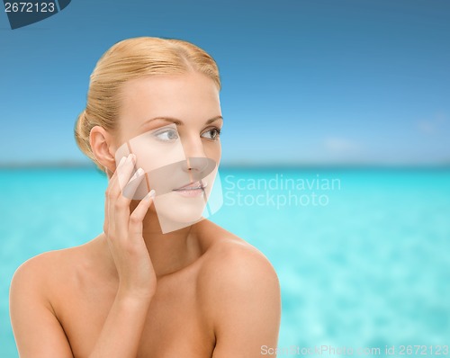 Image of beautiful woman touching her face skin