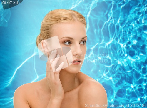 Image of beautiful woman touching her face skin