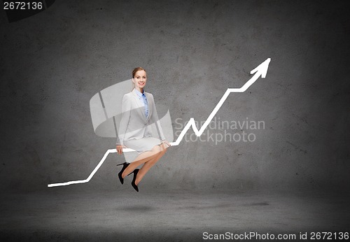 Image of smiling businesswoman sitting on chart