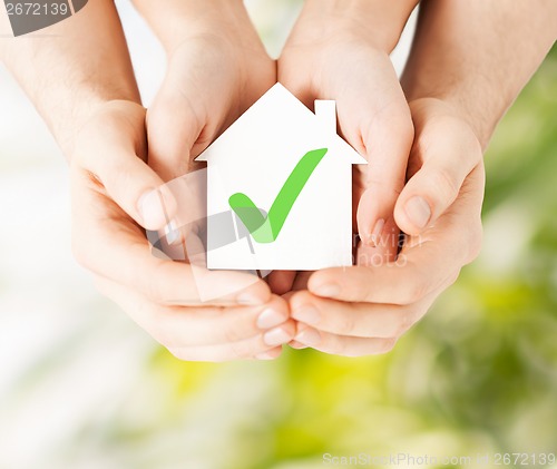 Image of hands holding house with check mark