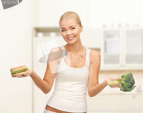 Image of smiling woman with broccoli and hamburger