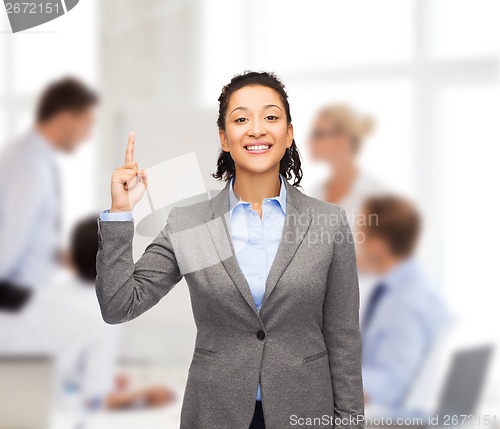 Image of smiling businesswoman with her finger up at office