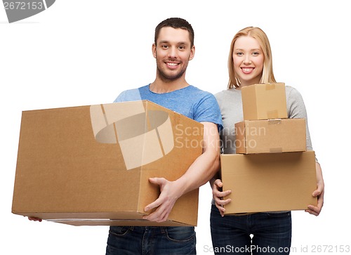 Image of smiling couple holding cardboard boxes