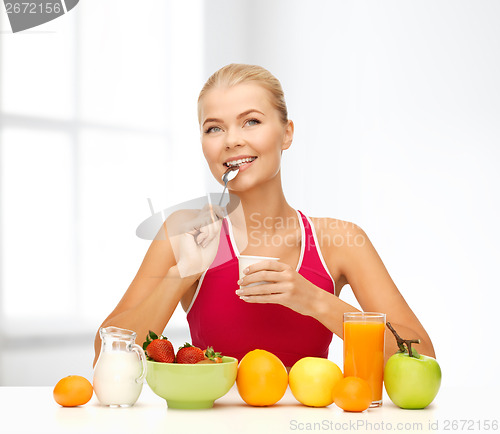 Image of young woman eating healthy breakfast