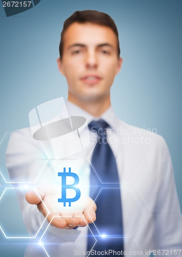 Image of friendly buisnessman showing bit coin on the palm