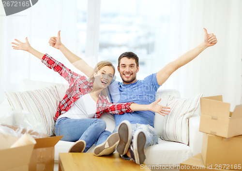 Image of smiling couple relaxing on sofa in new home