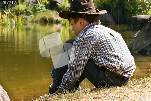 Image of Child sitting by outback billabong