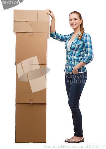 Image of young woman standing next to tower of boxes