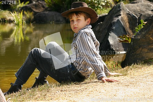 Image of Rural boy sitting by banks of a river