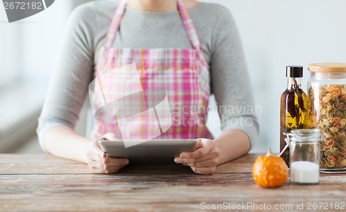 Image of closeup of woman reading recipe from tablet pc