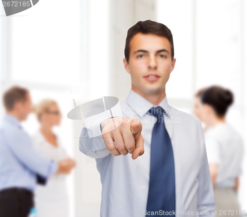 Image of friendly young buisnessman pointing finger