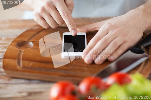 Image of closeup of man pointing finger to smartphone